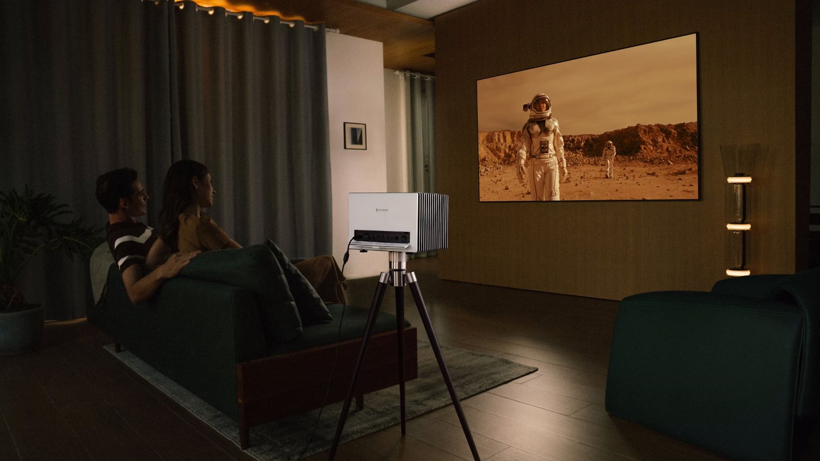 A couple on the sofa watching a movie projected on the wall