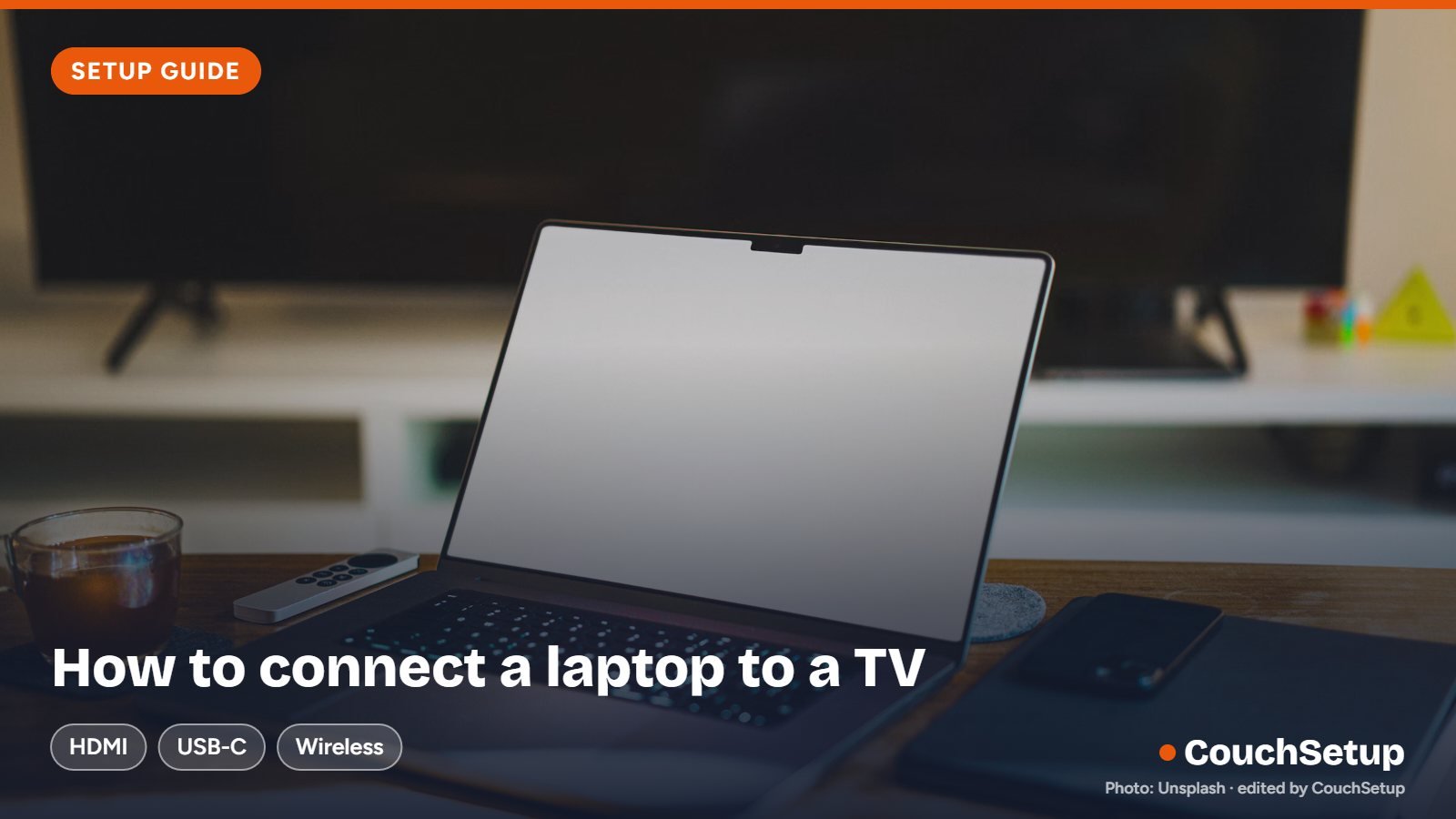 A laptop on a table in front of a TV