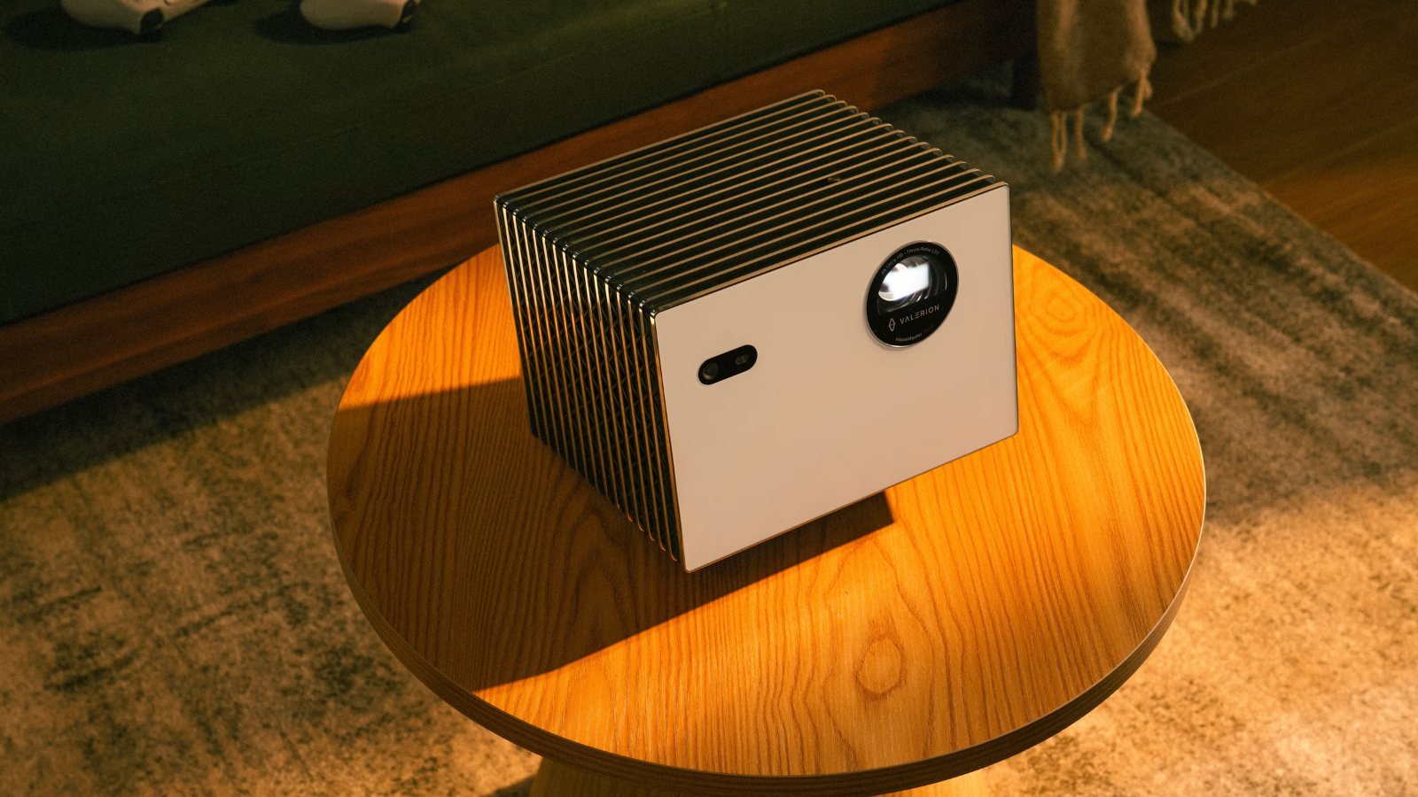 A small portable projector on a round coffee table
